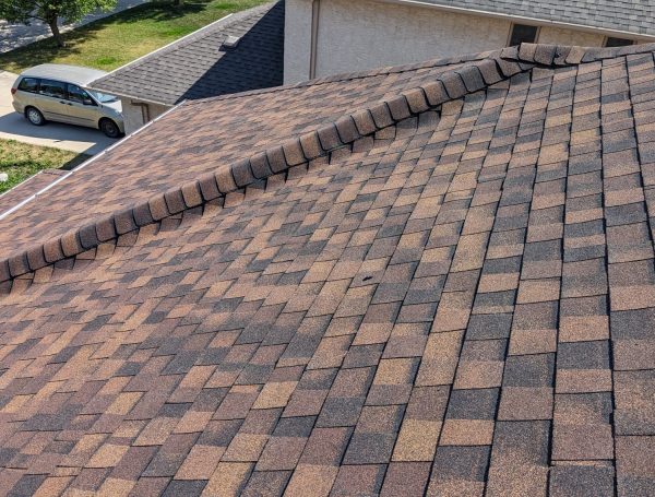 professional roofing crew installing asphalt shingles on house roof