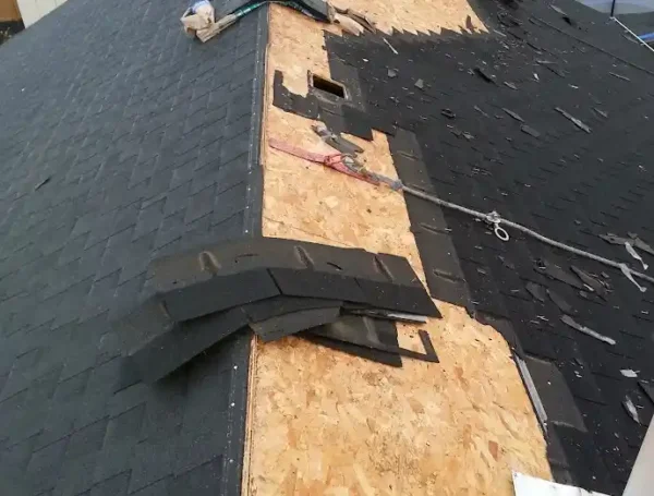 Roof maintenance work in progress on residential asphalt shingle roof