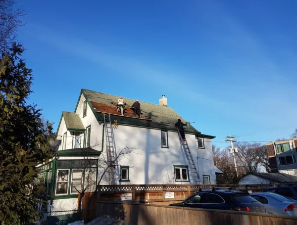 Roof maintenance work in progress on residential asphalt shingle roof