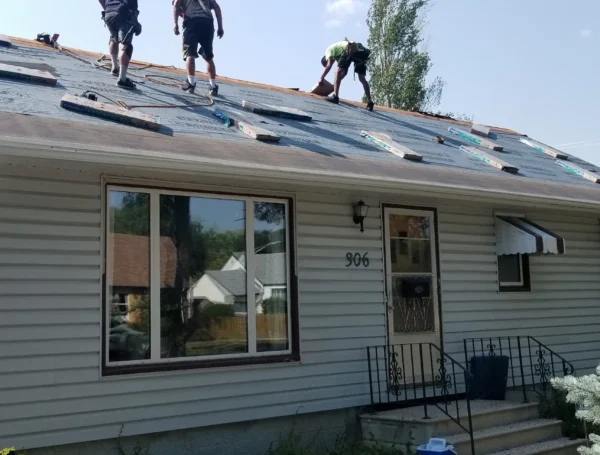 Roofing contractor inspecting and repairing roof damage