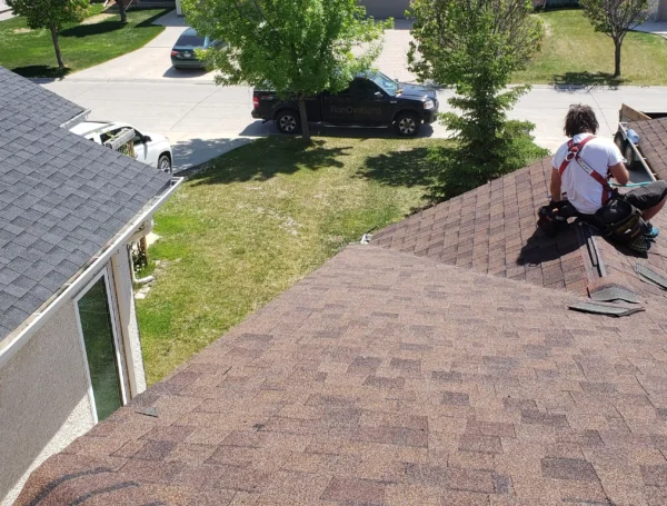 Roofing contractor inspecting and repairing roof damage