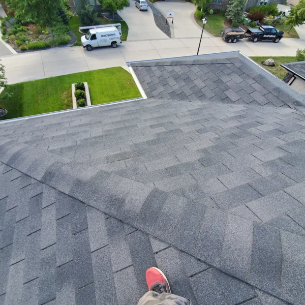 Roofer working on shingle roof maintenance and repair