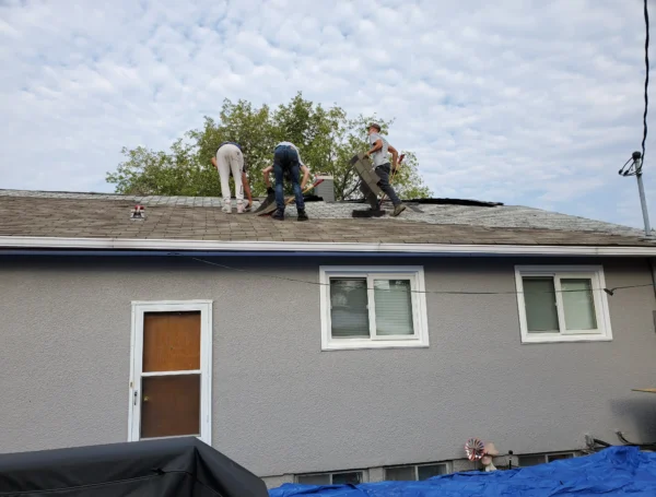 Roofing technician performing roof maintenance on house rooftop