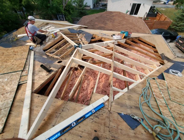 Roofing technician performing roof maintenance on house rooftop