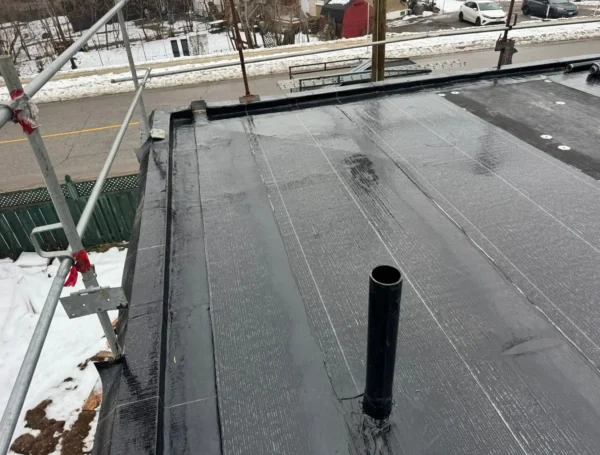 roofing contractor applying flat roof membrane