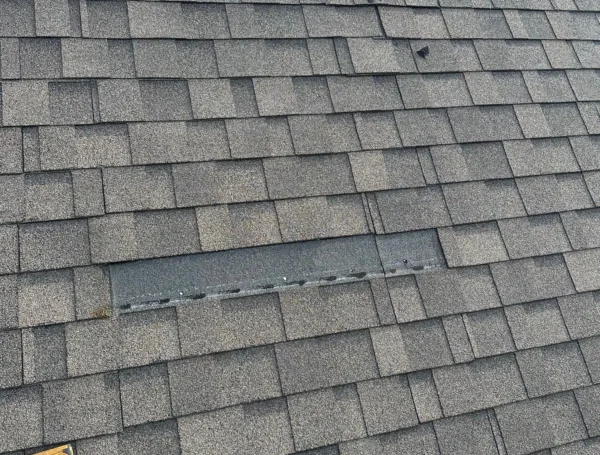 Roofing contractor inspecting and repairing roof damage