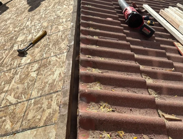 Roofing contractor inspecting and repairing roof damage
