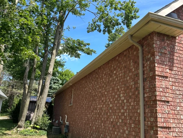 Professional installation of eavestrough and soffit on house roofline