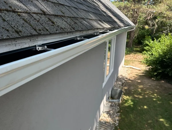 Professional installation of eavestrough and soffit on house roofline