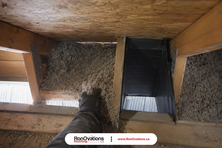 Blown-in insulation blocking a soffit intake at the edge of an attic