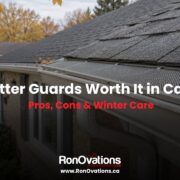 Aluminum eavestrough with a leaf guard along the roof edge of a Canadian home in autumn.